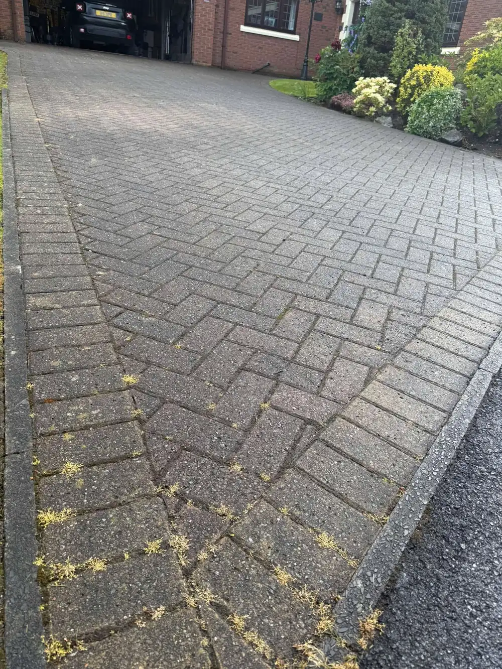 Weathered buff block paving driveway before cleaning