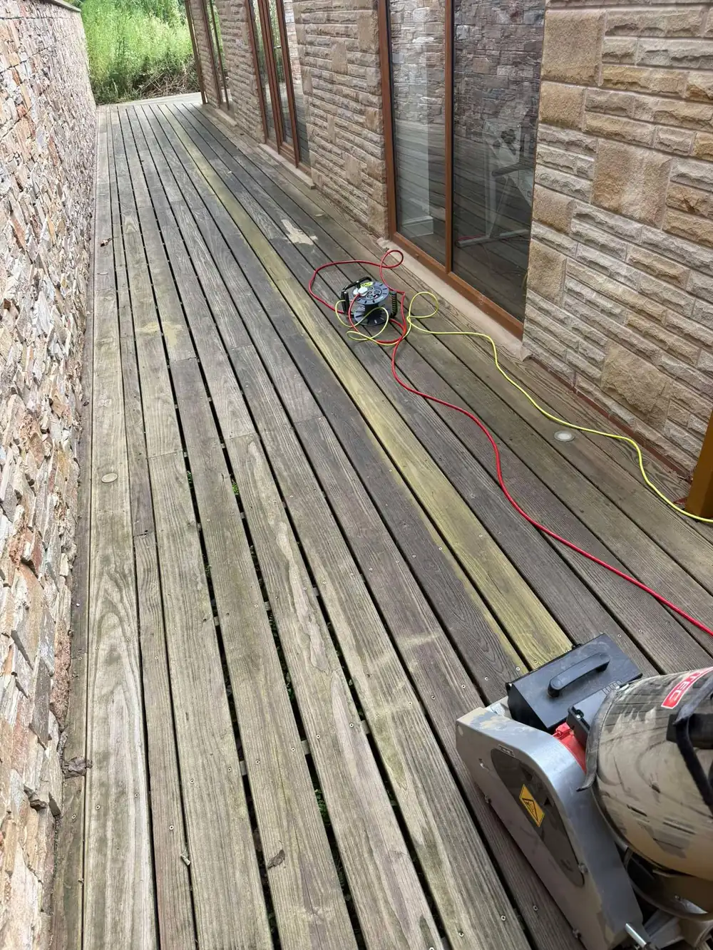 Greyed, algae-covered decking boardwalk before cleaning